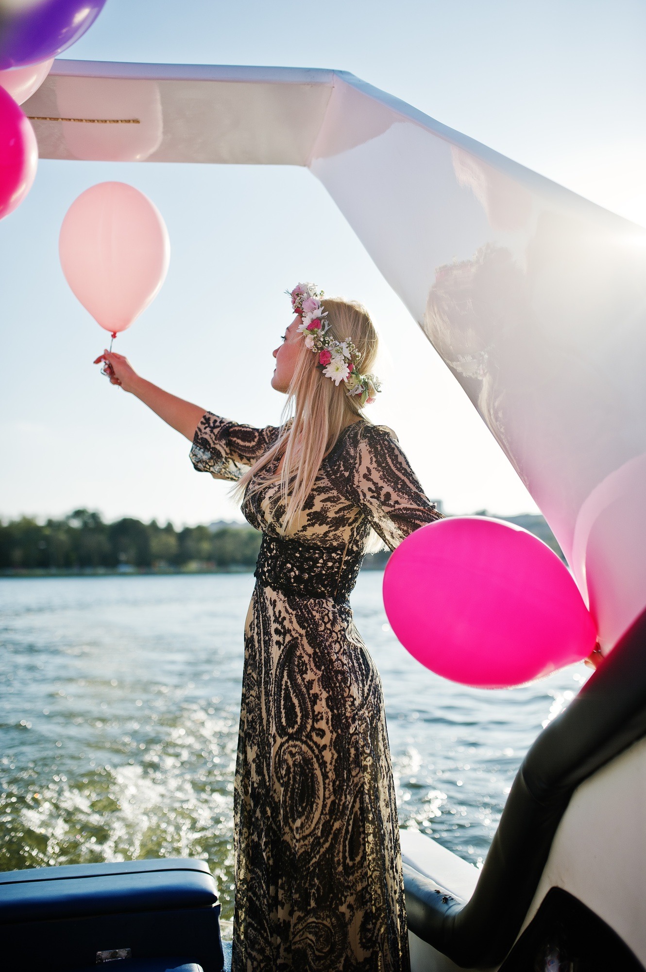 Blonde woman wearing a wreath sitting on a yacht at a hen party.