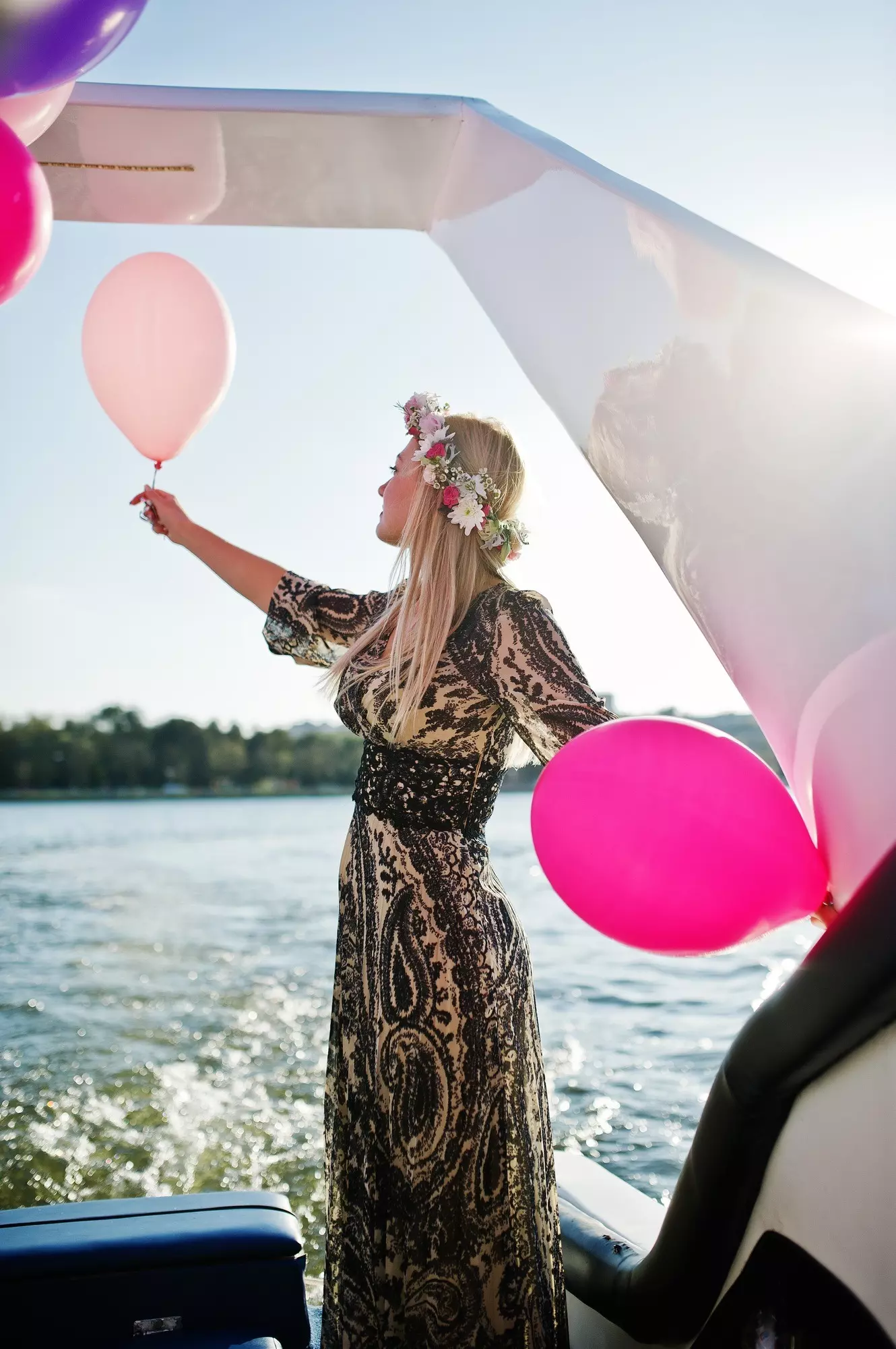 Blonde girl in wreath sitting on yacht at hen party.