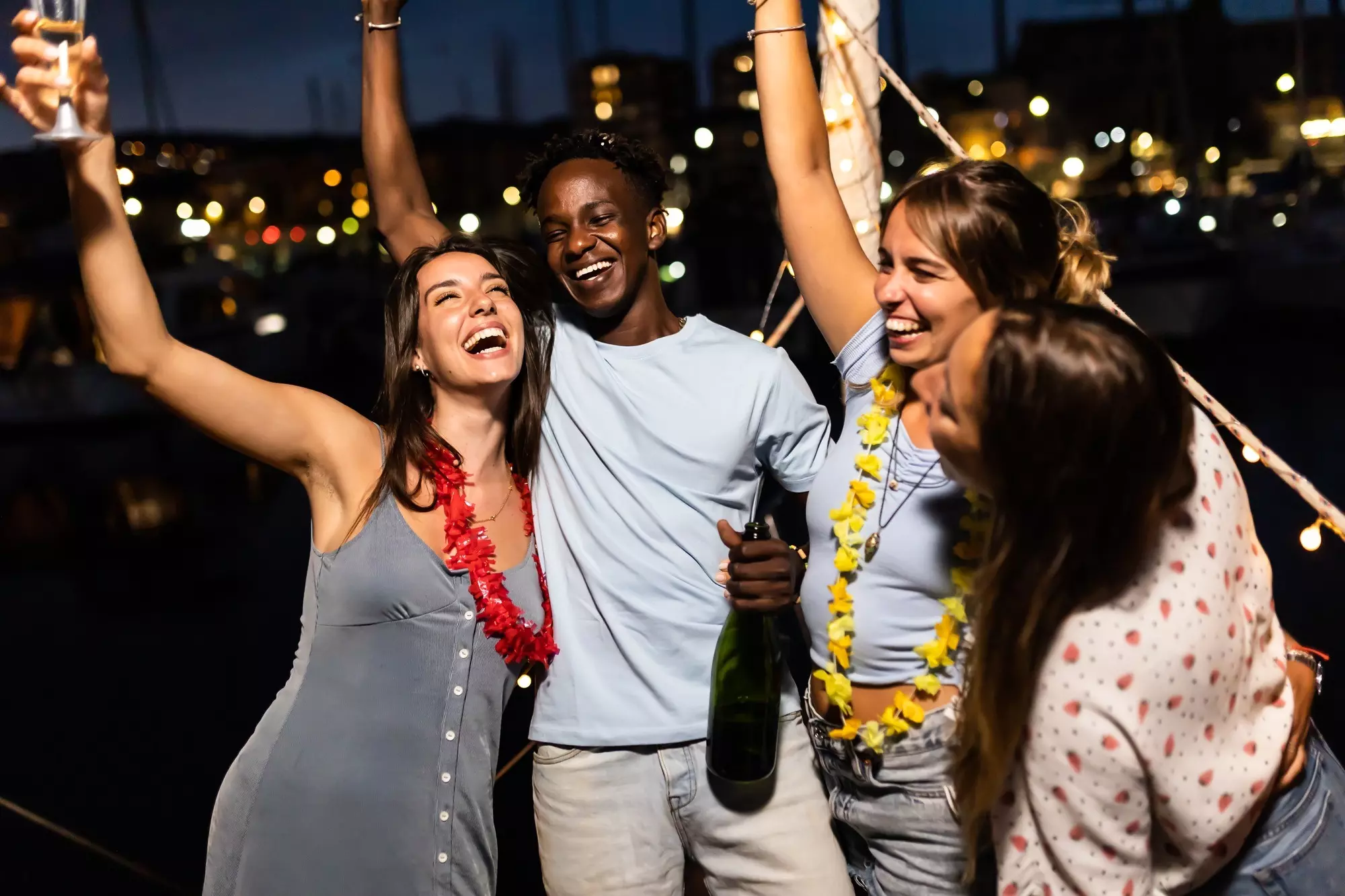 Happy young friends celebrating together on boat party in summer vacation