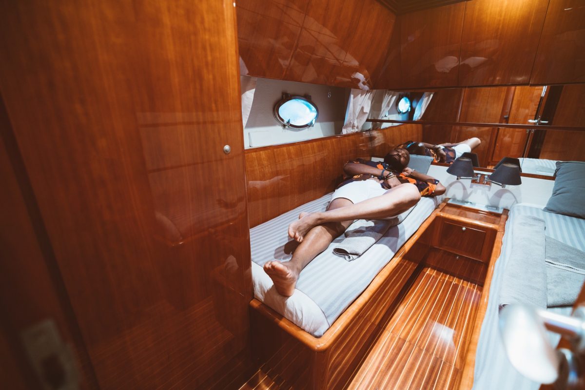 Black guy on a bed in a yacht cabin