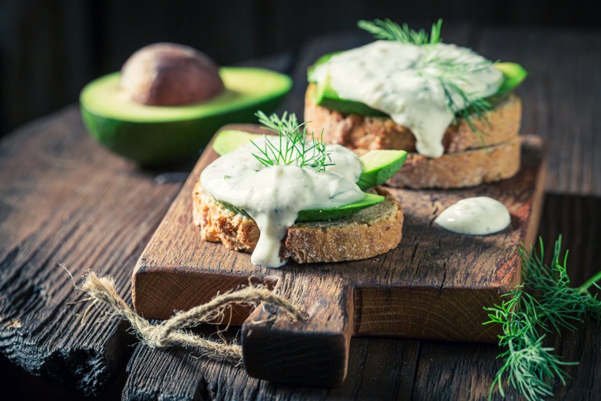 Closeup of sandwich with avocado and tzatziki sauce