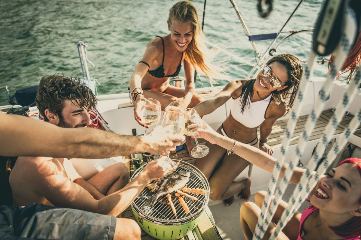 Friends making fish barbecue on the yacht