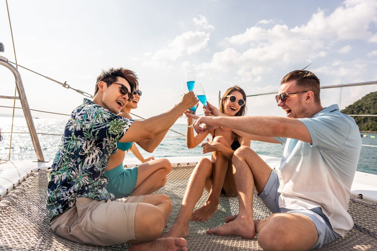 Group of diverse friends drink champagne while having a party in yacht.