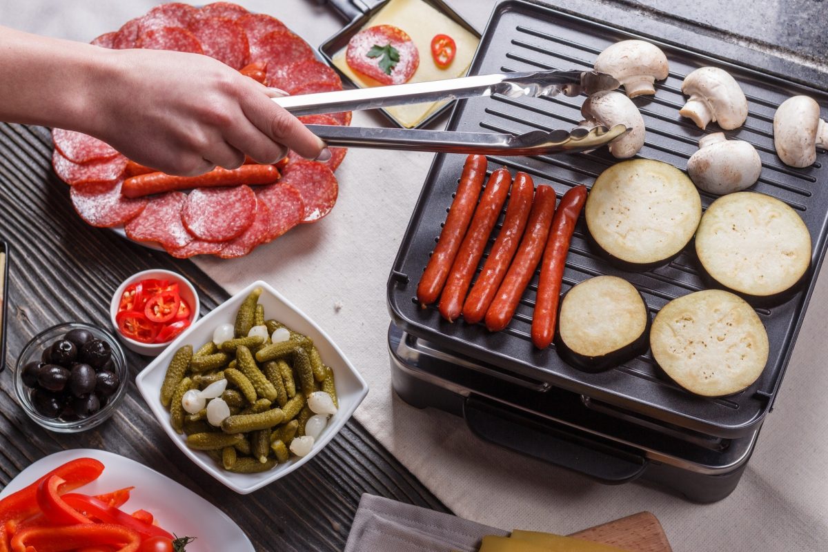 young woman is preparing a traditional Swiss cheese raclette